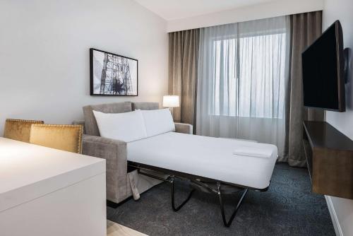 a living room with a couch and a table in a hotel room at Embassy Suites by Hilton Houston West - Katy in Houston