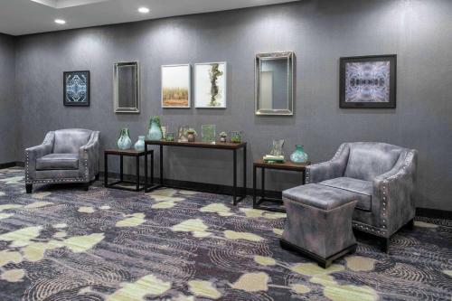 a waiting room with two chairs and a table and mirrors at Homewood Suites By Hilton Lansing Eastwood in Lansing
