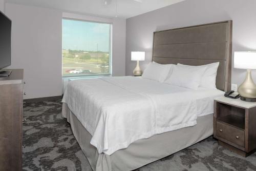 une chambre d'hôtel avec un grand lit et une fenêtre dans l'établissement Homewood Suites By Hilton Lansing Eastwood, à Lansing