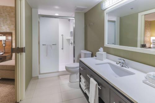 a bathroom with a sink and a toilet and a mirror at Home2 Suites Kansas City Downtown in Kansas City