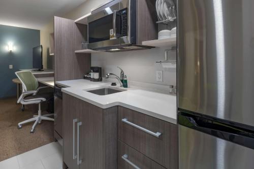 a small kitchen with a sink and a refrigerator at Home2 Suites by Hilton Kingman in Kingman