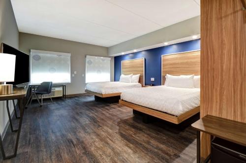 una camera d'albergo con 2 letti e una scrivania di Tru By Hilton Raleigh Durham Airport a Morrisville