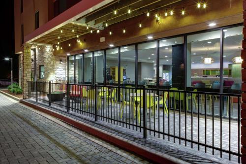 a building with a fence on a street at night at Home2 Suites By Hilton Fort Collins in Fort Collins