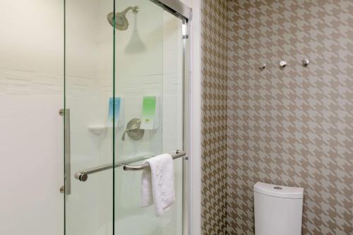 y baño con ducha de cristal y aseo. en Home2 Suites By Hilton Fort Collins en Fort Collins