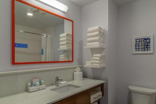 a bathroom with a sink and a mirror and a toilet at Hampton Inn Bourbonnais Kankakee in Bourbonnais