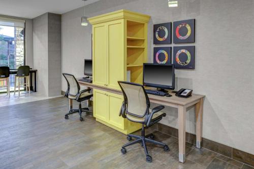 an office with three chairs and a desk with a computer at Home2 Suites By Hilton Fort Collins in Fort Collins