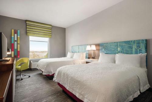 a hotel room with two beds and a window at Hampton Inn Brooklyn Park in Brooklyn Park