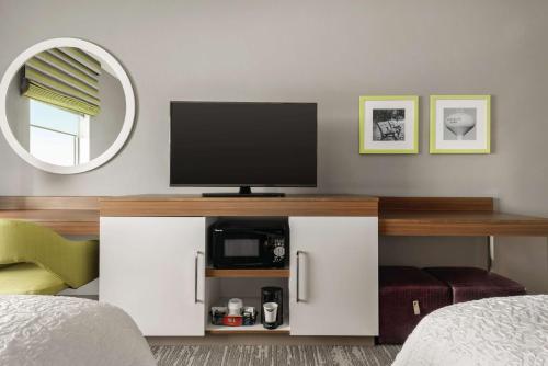 a living room with a tv and a bed at Hampton Inn Brooklyn Park in Brooklyn Park