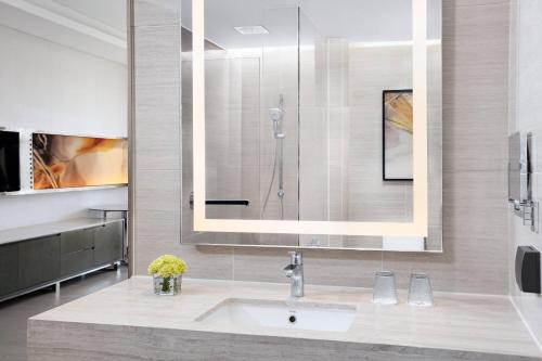 a bathroom with a sink and a shower at Courtyard by Marriott Tianjin Hongqiao in Tianjin