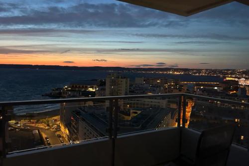 - un balcon offrant une vue sur la ville la nuit dans l'établissement L'Horizon - 3 ch climatisé avec vue mer incroyable, à Marseille
