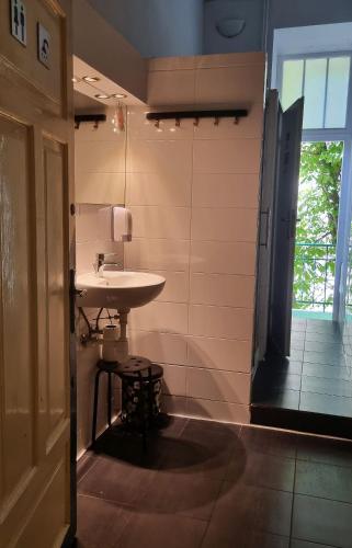 a bathroom with a sink and a window at Green Cat Rooms in Krakow