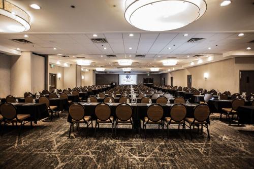 a conference room with tables and chairs and a screen at DoubleTree by Hilton Roseville Minneapolis in Roseville