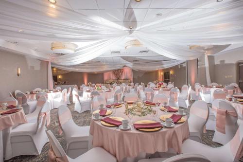 a banquet hall with white tables and white chairs at DoubleTree by Hilton Roseville Minneapolis in Roseville