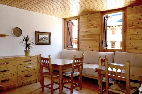 a dining room with a couch and a table and chairs at La Coma in Taüll