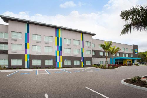 ein großes Gebäude mit bunten Streifen auf einem Parkplatz in der Unterkunft Tru By Hilton Bradenton I-75, FL in Bradenton