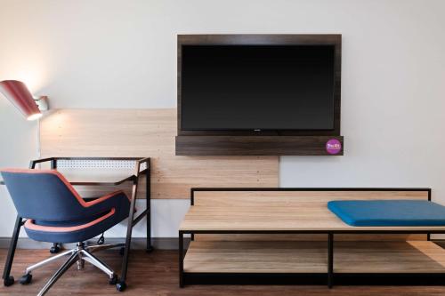 a room with a desk and a chair and a tv at Tru By Hilton Bradenton I-75, FL in Bradenton