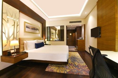 a hotel room with a bed and a tv at DoubleTree by Hilton Gurugram Baani Square in Gurgaon