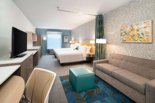 Habitación de hotel con sofá y cama en Home2 Suites By Hilton Brunswick, en Brunswick