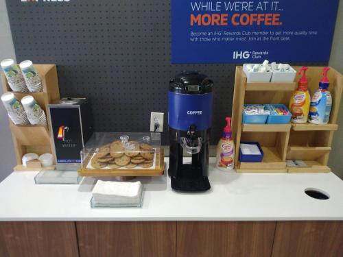 a counter with a coffee maker and some pastries at Holiday Inn Express Hotel & Suites Albuquerque Midtown by IHG in Albuquerque