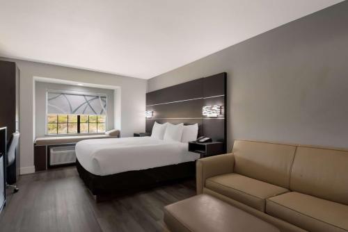 um quarto de hotel com uma cama e um sofá em Best Western SeaWorld San Antonio em San Antonio