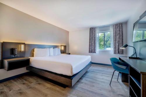 een hotelkamer met een groot bed en een bureau bij Motel 6 Bethel, CT - Danbury in Bethel