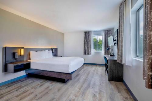 a hotel room with a large bed and a desk at Motel 6 Bethel, CT - Danbury in Bethel