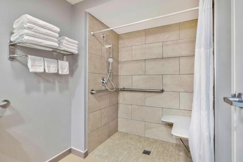 ein Bad mit einer Dusche und einem WC mit Handtüchern in der Unterkunft Motel 6 Bethel, CT - Danbury in Bethel