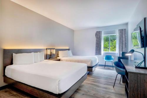 a hotel room with two beds and a desk at Motel 6 Bethel, CT - Danbury in Bethel