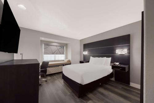 a hotel room with a bed and a desk and a computer at Best Western SeaWorld San Antonio in San Antonio