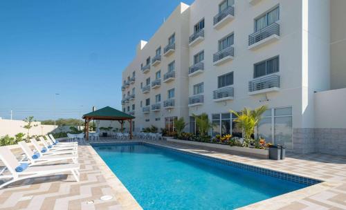 een hotel met een zwembad voor een gebouw bij Super 8 by Wyndham Manzanillo 