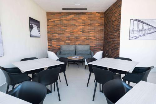 a dining room with tables and chairs and a couch at Super 8 by Wyndham Manzanillo in Pepillo Salcedo
