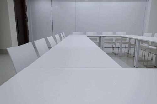 a white room with white tables and white chairs at Super 8 by Wyndham Manzanillo in Pepillo Salcedo