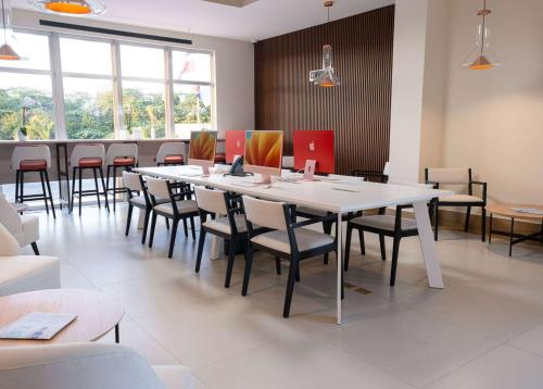 a dining room with a white table and chairs at Super 8 by Wyndham Manzanillo in Pepillo Salcedo