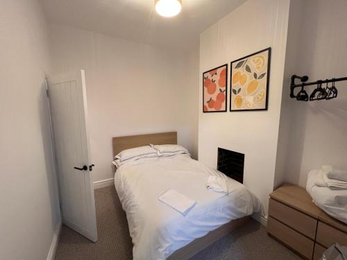 a small bedroom with a bed and a fireplace at Altrincham Terrace - 2 Bedroom House - Free Parking - Sleeps 6 - Near Tram Stop in Manchester