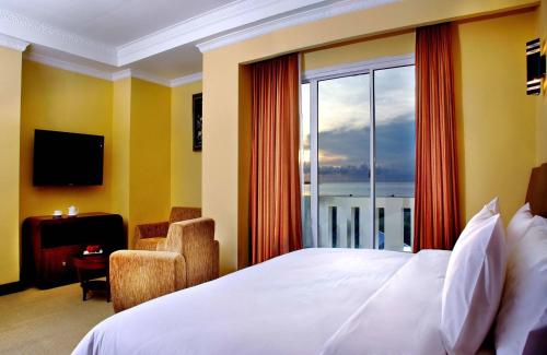 a hotel room with a bed and a large window at Aston Niu Manokwari Hotel & Conference Center in Manokwari