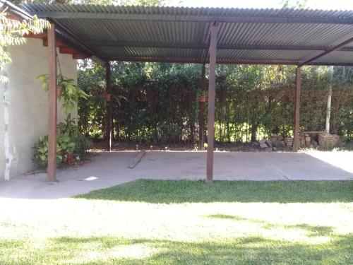 a patio with a metal cover and grass at La rana alquiler temporal in Reyes