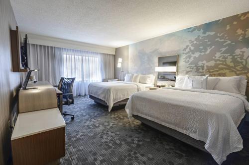 a hotel room with two beds and a window at Courtyard by Marriott Cleveland Willoughby in Willoughby