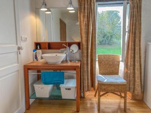 un bagno con un lavandino, uno specchio e una sedia di Maison Sauveterre a Fourquies