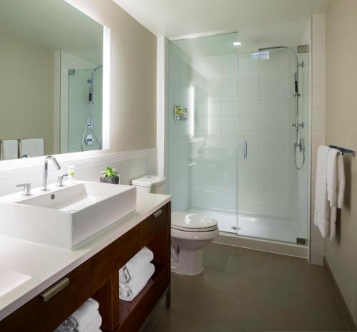 a bathroom with a sink and a shower and a toilet at Element Vancouver Metrotown in Burnaby