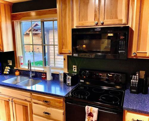 cocina con fogones, fregadero y microondas en Cedar Mountain Suite E, en Grants Pass