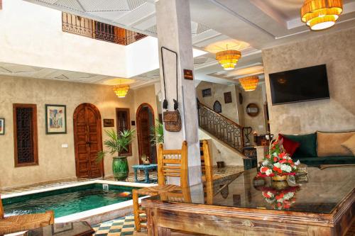 a living room with a swimming pool and a house at Riad Belikoss Pool & SPA in Marrakesh