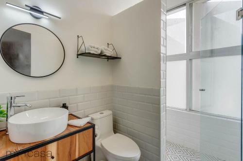 y baño con lavabo, espejo y aseo. en Apartment in Quiet District, 8 min Walk from Masaryk, en Ciudad de México