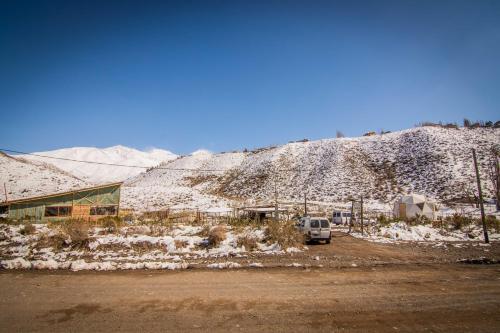 a van parked in front of a snow covered mountain at Domos Andinos HostCamp in Potrerillos