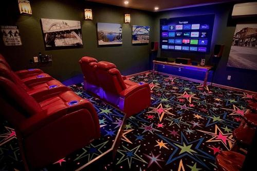 ein Filmzimmer mit roten Stühlen und einem Flachbild-TV in der Unterkunft Cedar A - Home Theater, Gamer Ready! in Grants Pass