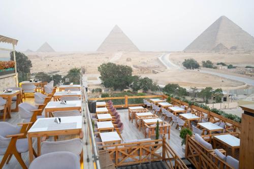 a view of the pyramids from a restaurant with tables and chairs at Great Pyramid Inn in Cairo