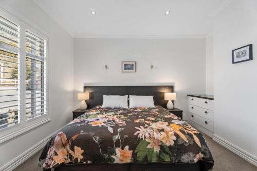um quarto com uma cama grande e uma colcha floral em Gold Rush Chalet - Cardrona Holiday Home em Cardrona
