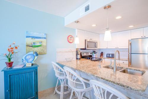 a kitchen with white cabinets and a blue wall at St Regis 3406 in North Topsail Beach