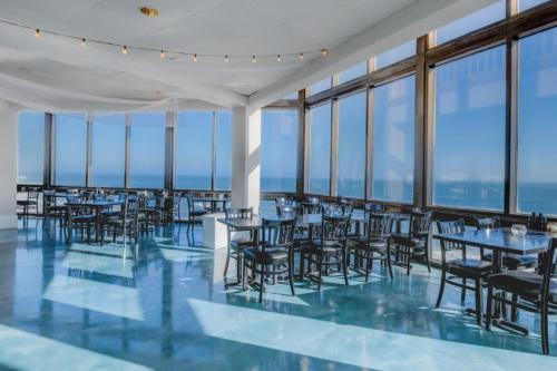a dining room with tables and chairs and windows at St Regis 3406 in North Topsail Beach