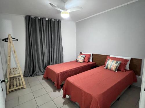 a room with two beds and a window at AeK apartamento conforto praia in Peruíbe