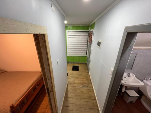 a hallway of a bathroom with a sink and a toilet at Departamento centro de Castro in Castro